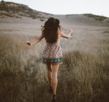 Photo by Clarisse Meyer woman wearing brown and green floral romper walking on green grass